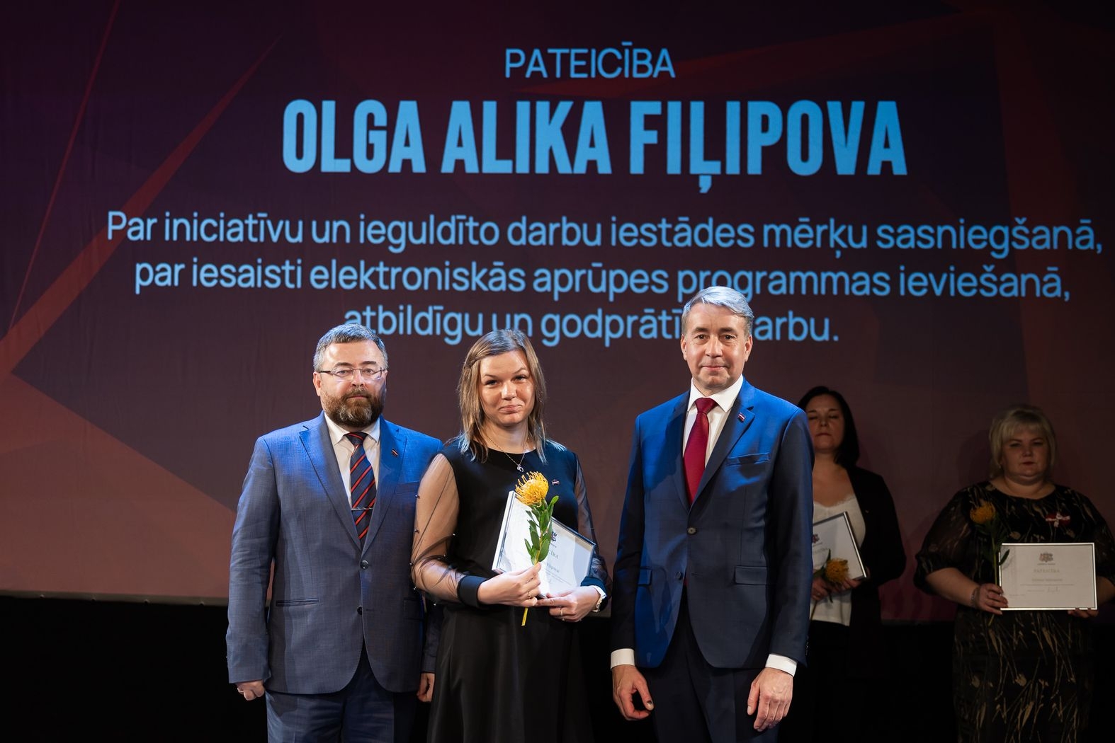 Pateicības raksta saņēmēja Olga Allika Fiļipova kopā ar Labklājības ministru un Valsts sekretārs